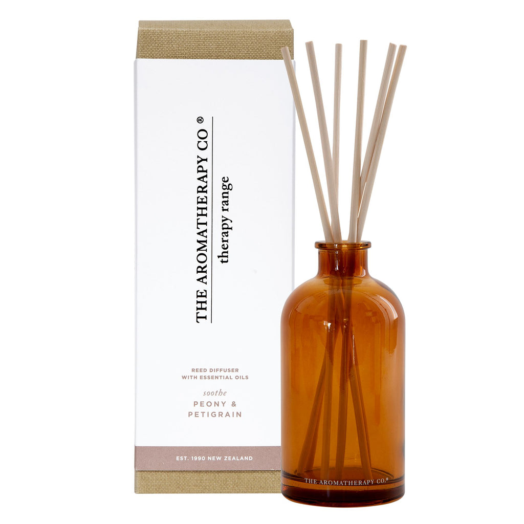 Dark amber transparent glass with small opening at the top. Long thin reed diffusers placed in the glass. 