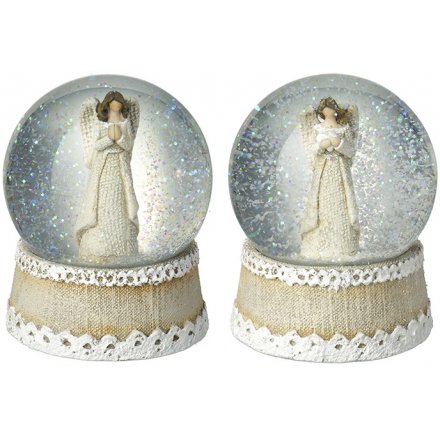 Two snow globes with angel figures on a white background
