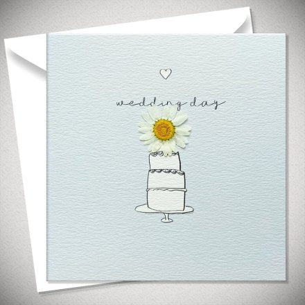square baby blue card with a cartoon three tier wedding cake and a pressed daisy flower on top. Above had 'wedding day' in script font and above that is a small cartoon heart. 