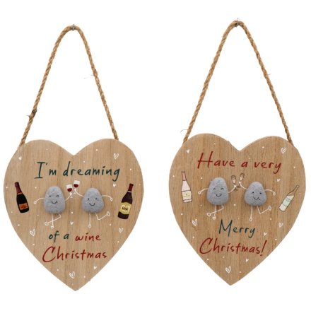 Two wooden heart-shaped plaques with festive messages and small stone figures on a white background.