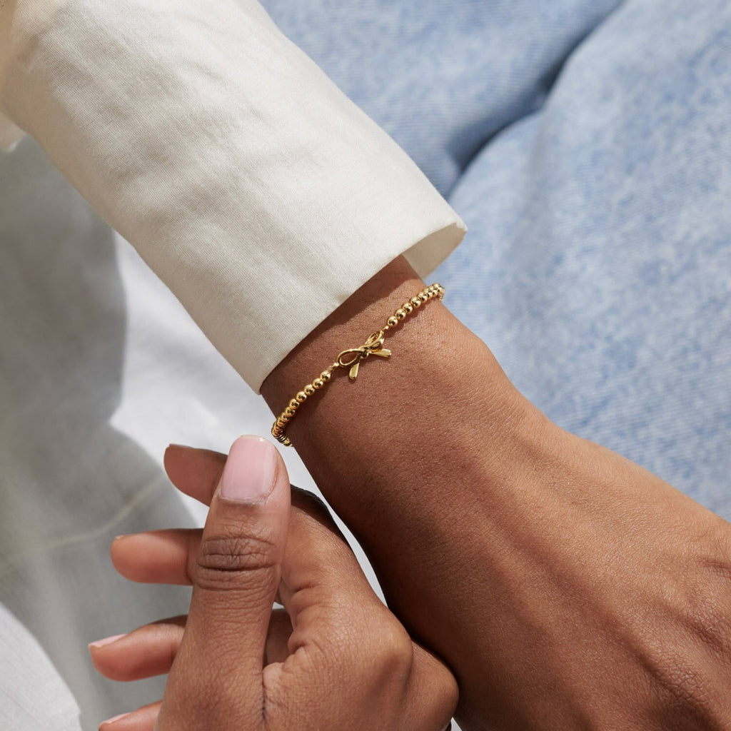Gold bracelet on a wrist with a blurred background