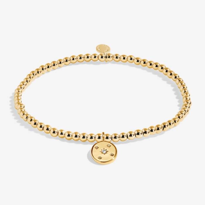 Gold bracelet with a round charm on a white background