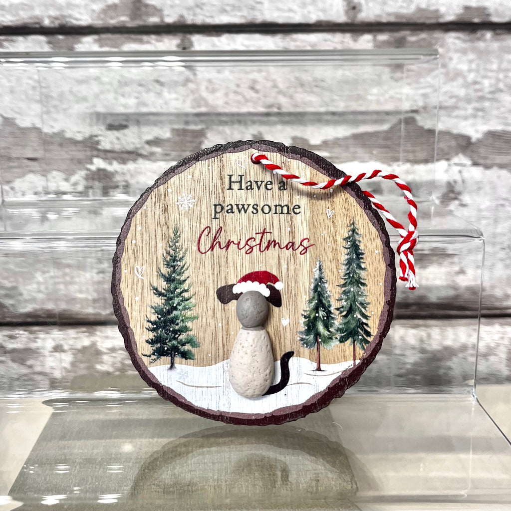 Wooden ornament with a cat wearing a Santa hat and text 'Have a Pawsome Christmas' on a wooden background.