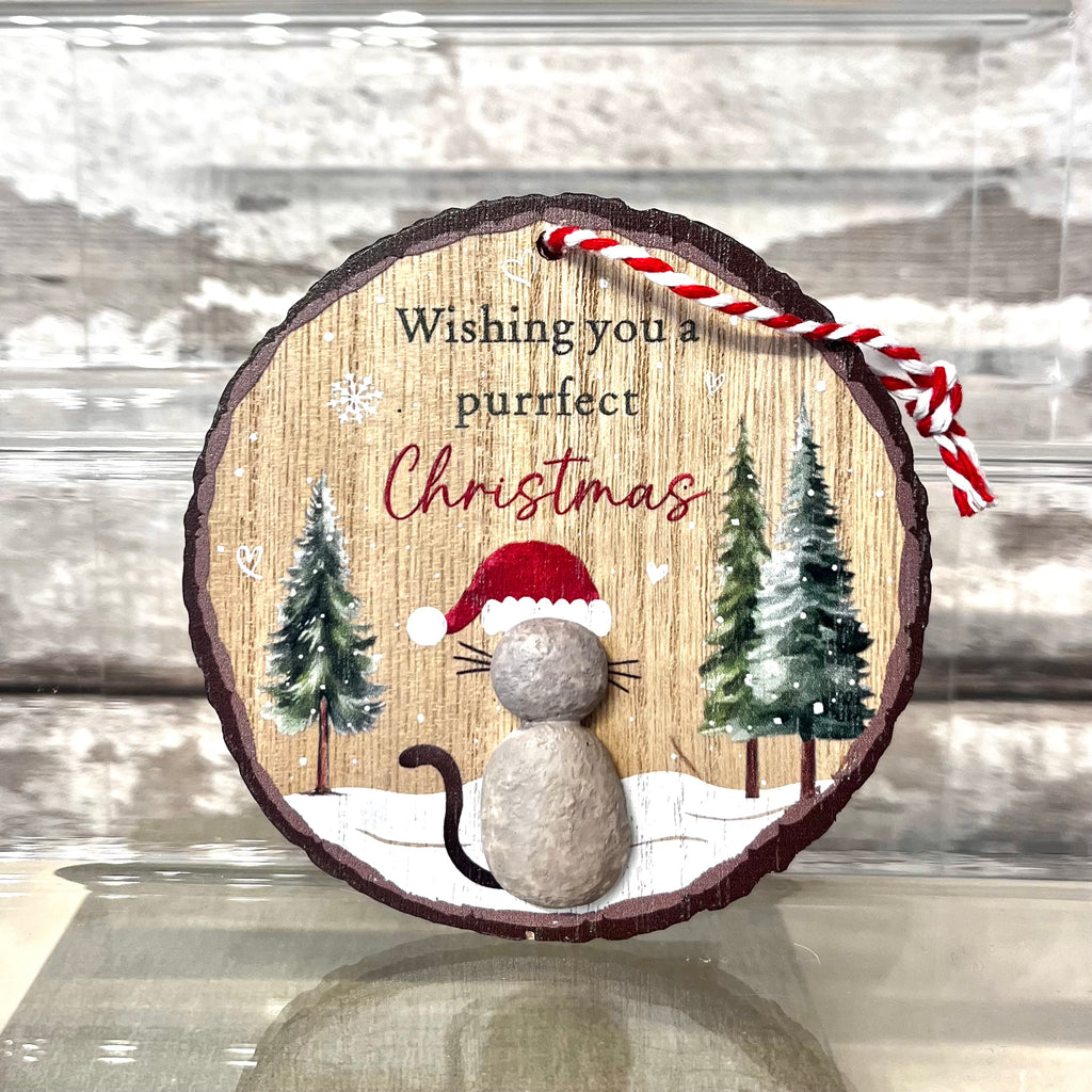Wooden ornament with a cat wearing a Santa hat and text 'Wishing you a purrfect Christmas' on a snowy background.