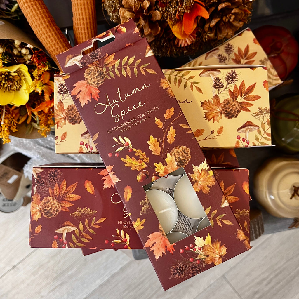 Decorative packaging for 'Autumn Spice' candles with floral and leaf design.