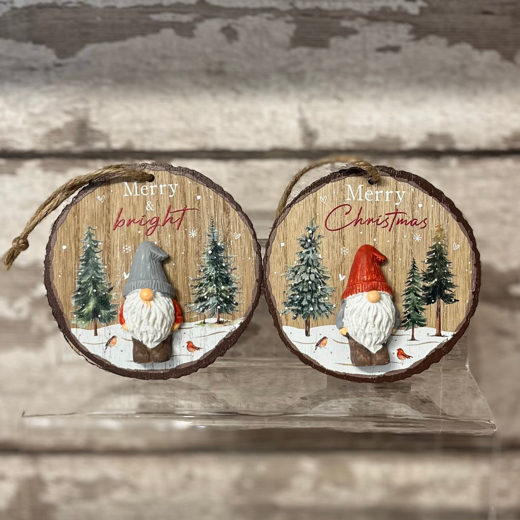 Two wooden Christmas ornaments with gnomes and snowy trees on a rustic wooden background.