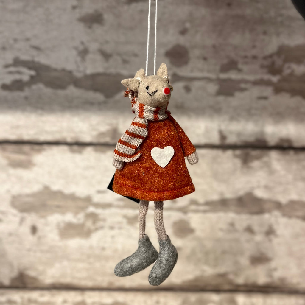 Textile mouse ornament with a brown dress and striped scarf hanging against a wooden background
