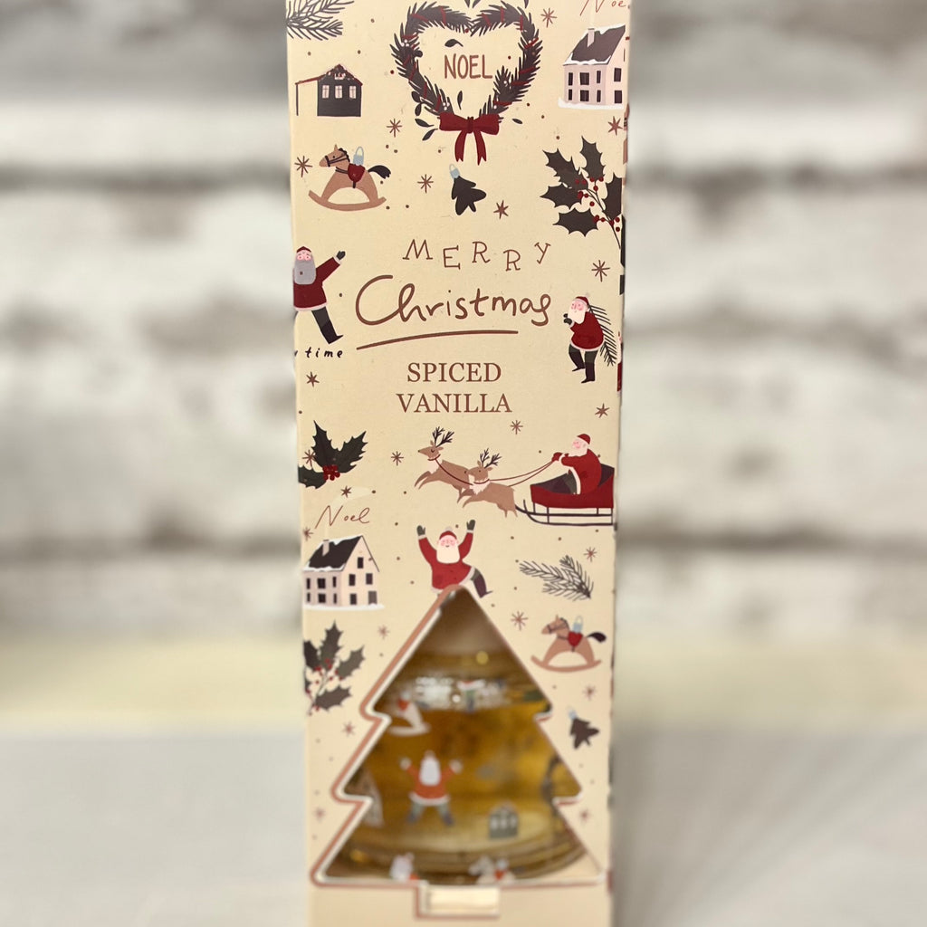 Christmas-themed spiced vanilla product packaging with festive illustrations on a beige background.