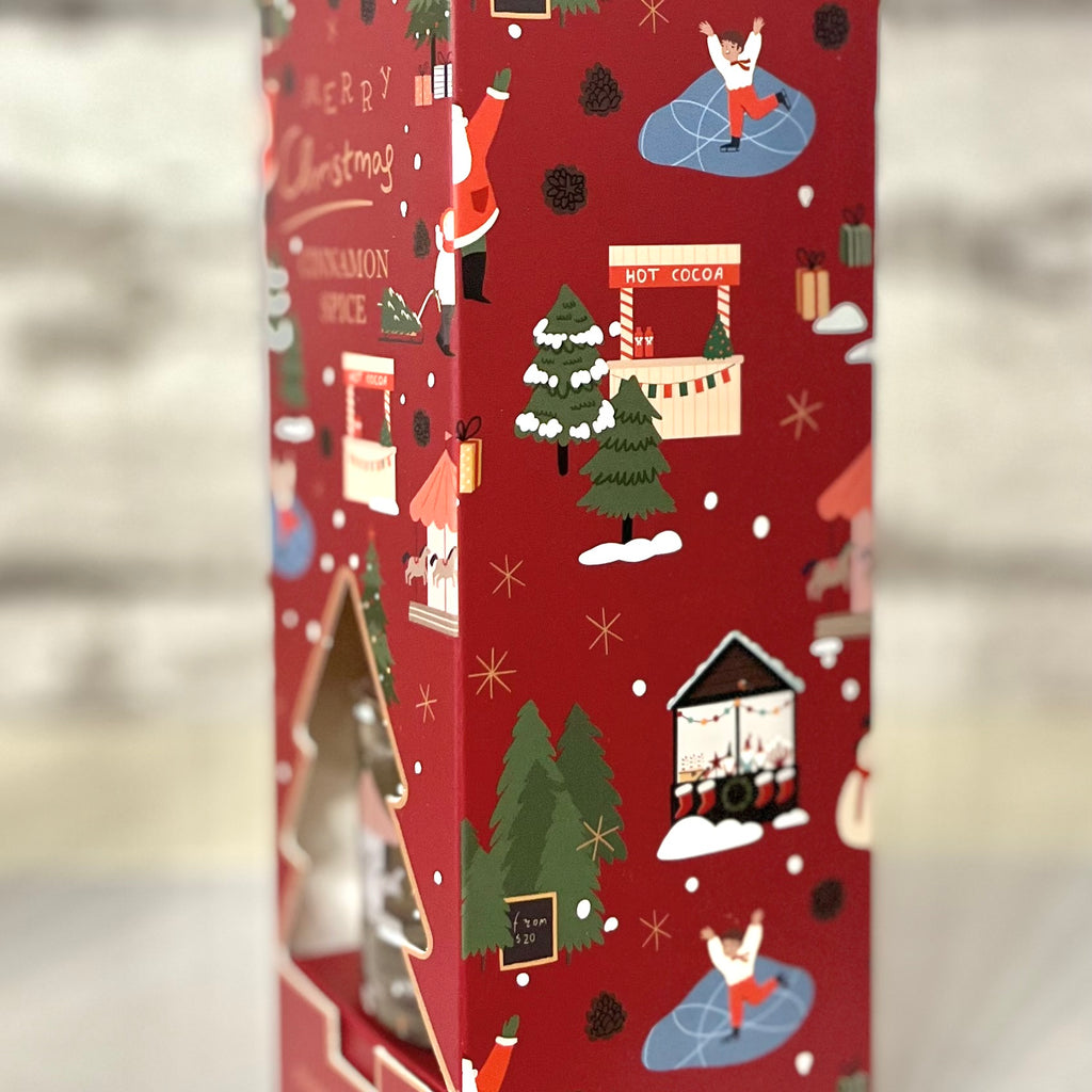 Red Christmas-themed box with festive illustrations on a blurred background