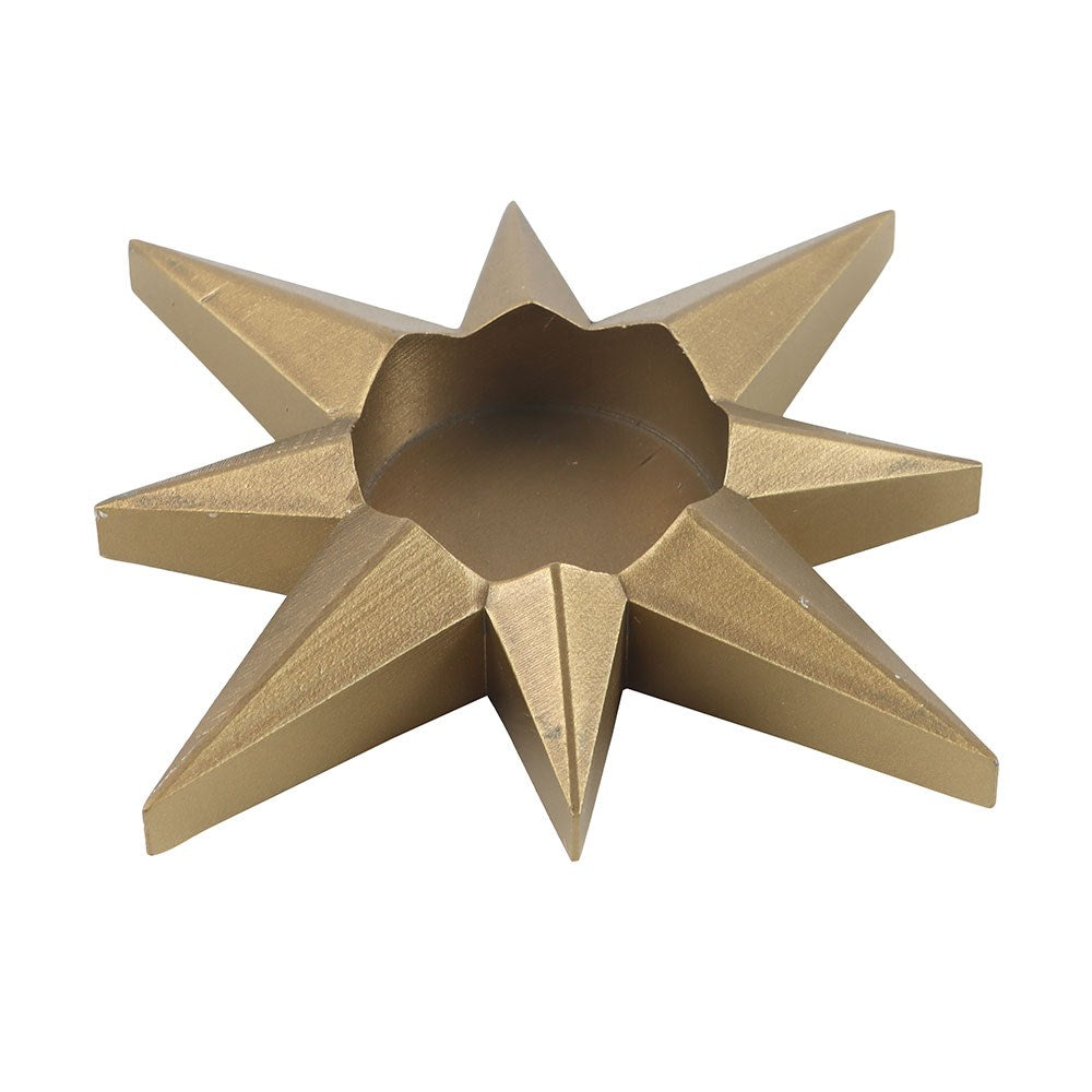 Gold star-shaped candle holder on a white background