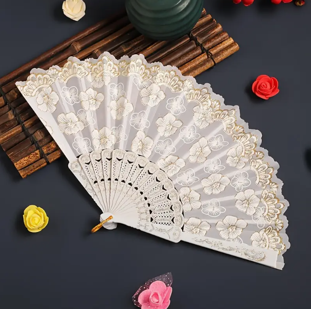 White folding fan with cherry blossom design on the fan. Frilled edge with intricate scallop design and gold detailing. 