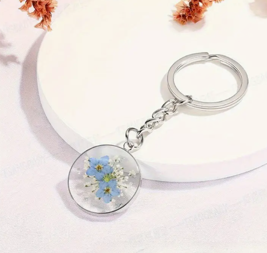 Silver keyring with round dangling charm of forget-me-not flower in resin