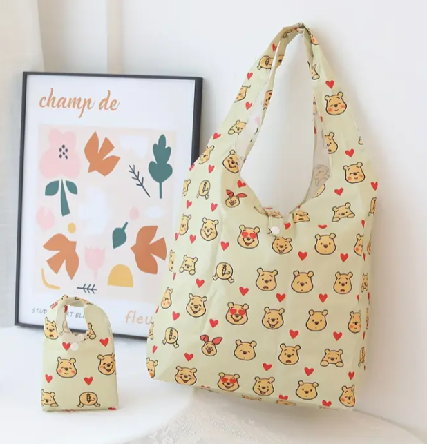Light green shoulder bag with repeating winnie the pooh face pattern with small red love hearts.