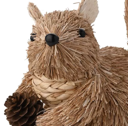 Woven squirrel decoration with a pine cone on a white background