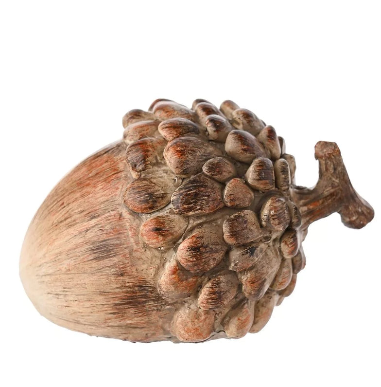 Rustic acorn decoration lying on its side on a white background 