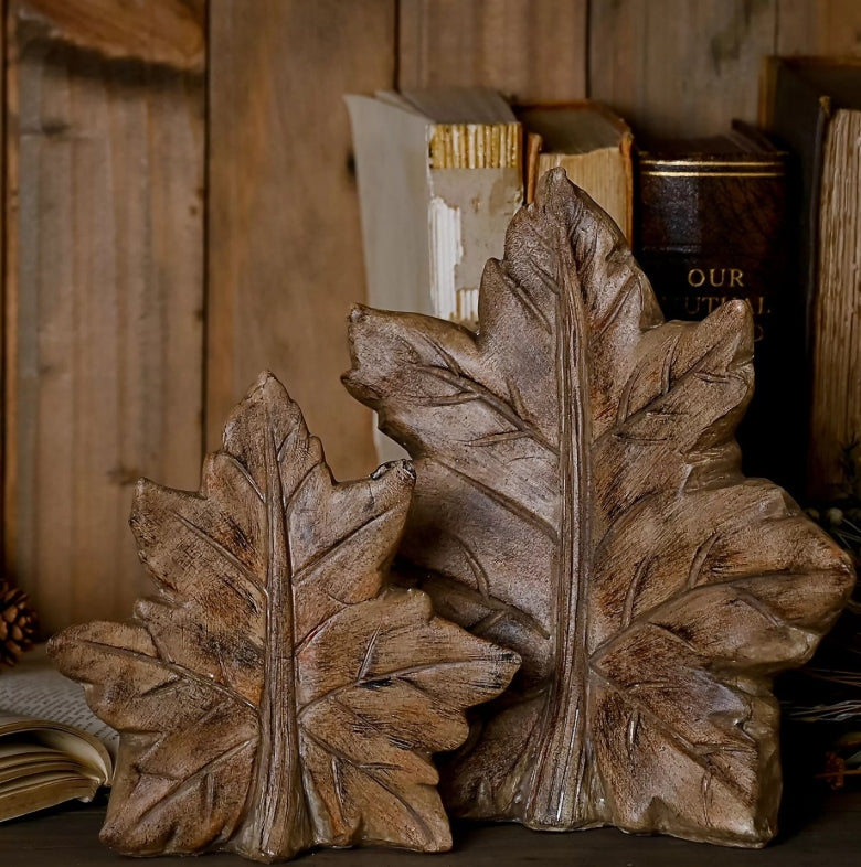 Two wooden leaf structures on a rustic wooden background with books