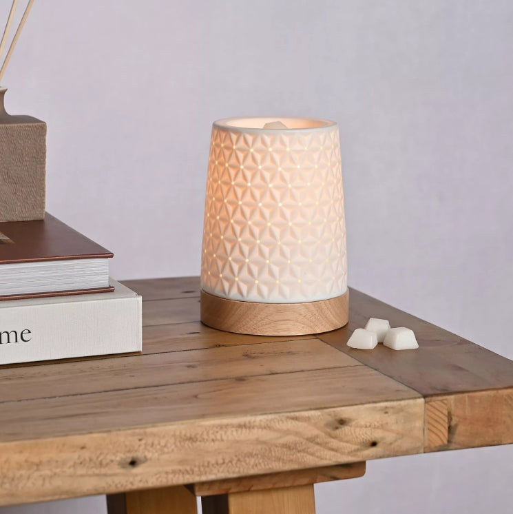 Decorative lamp on a wooden surface with books and small items.