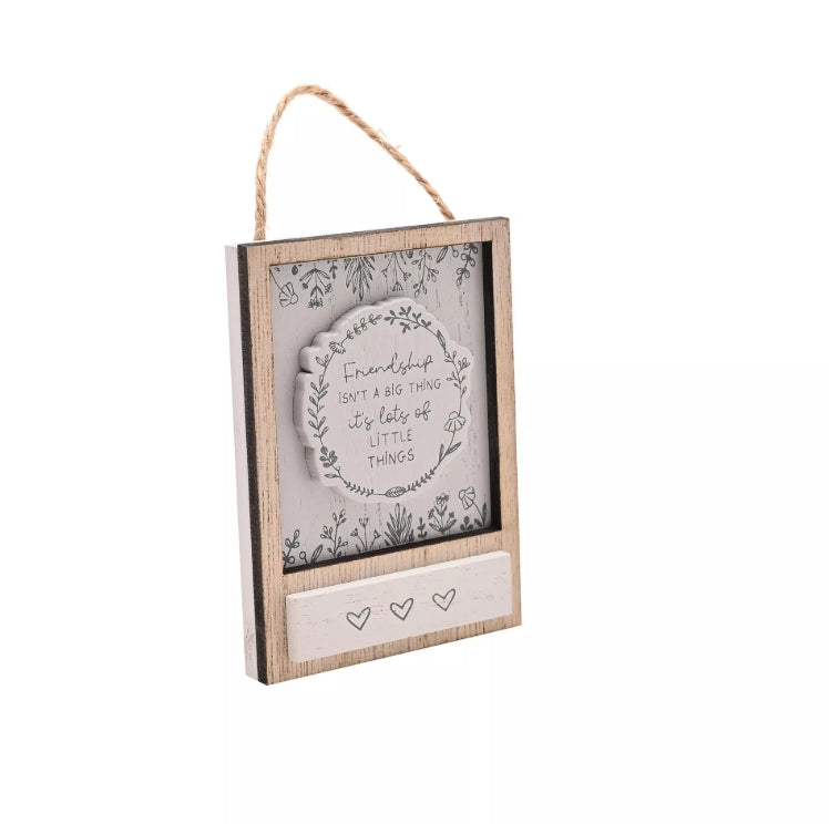 Decorative wall hanging with a wooden frame and text on a white background
