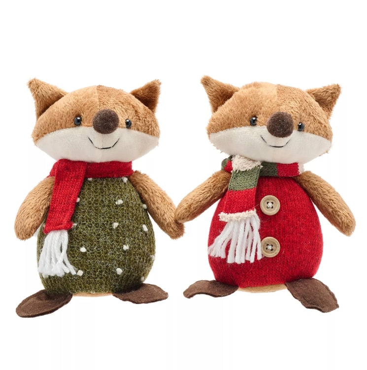 Two plush fox toys wearing knitted sweaters and scarves on a white background