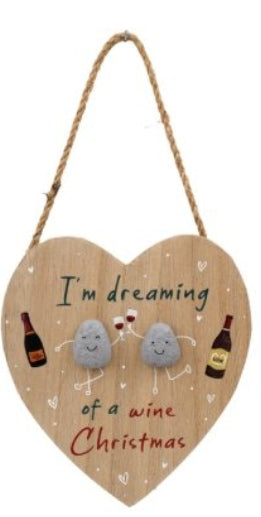 Heart-shaped wooden sign with cartoon eggs and text 'I'm dreaming of a wine Christmas' on a white background.